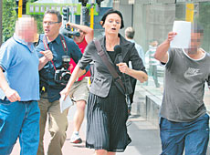 Suspect K (far right) and an associate (far left) evade the media outside the Auckland District Court yesterday.