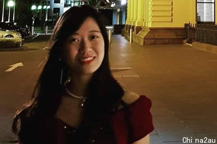 Meimi Wong smiling at night in front of a building, 