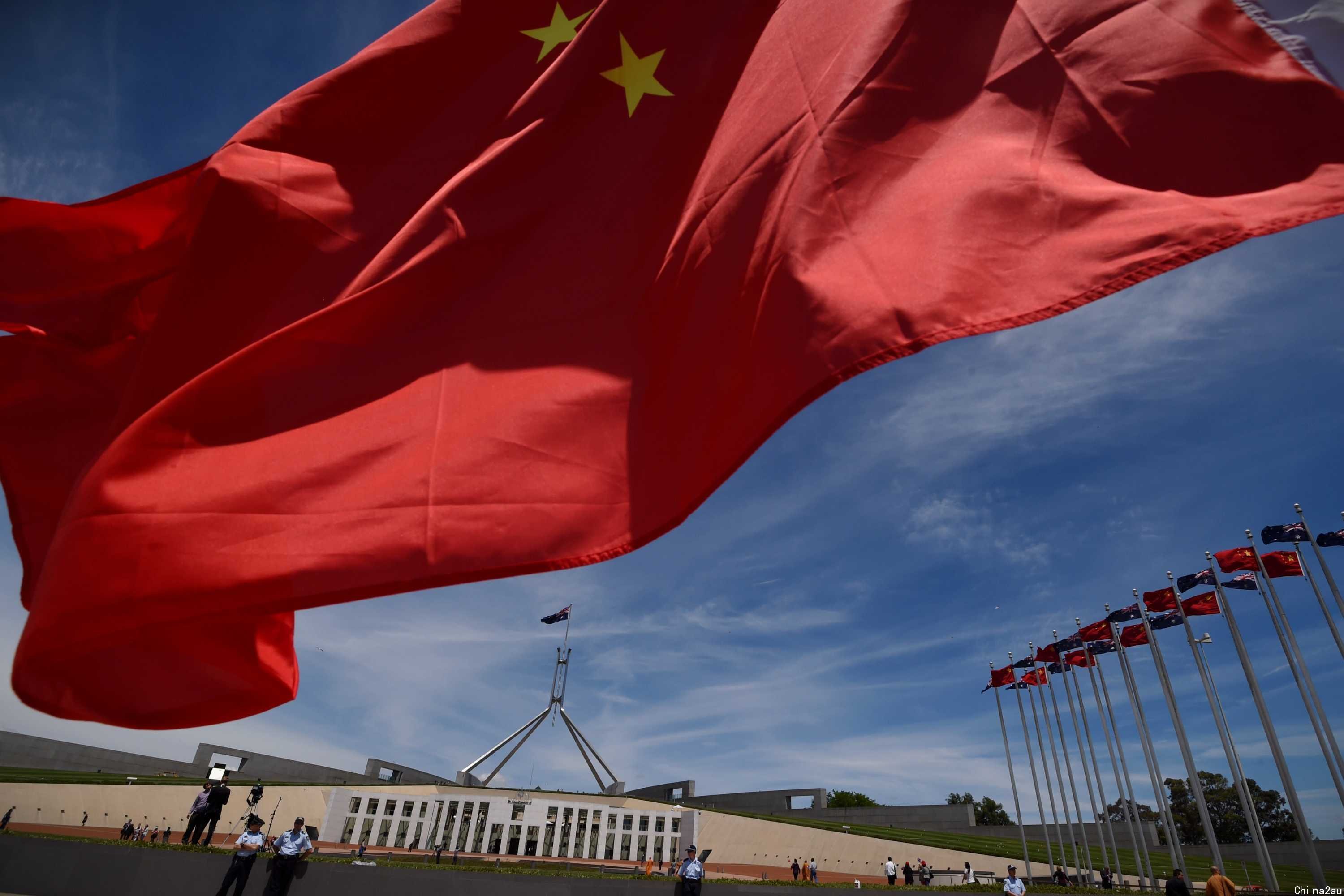 Chinese flags fly high outside the Australian Parliament House in Canberra