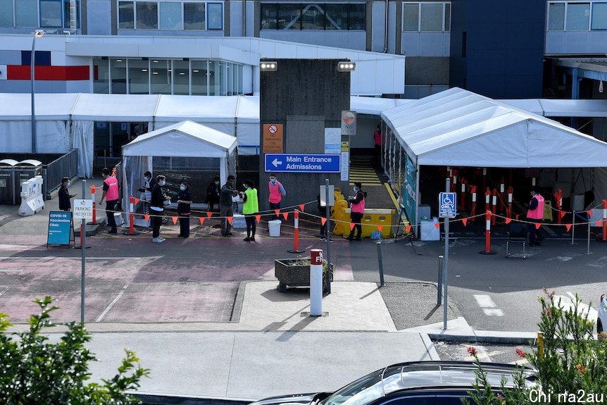 people lining up outside a vaccination hub