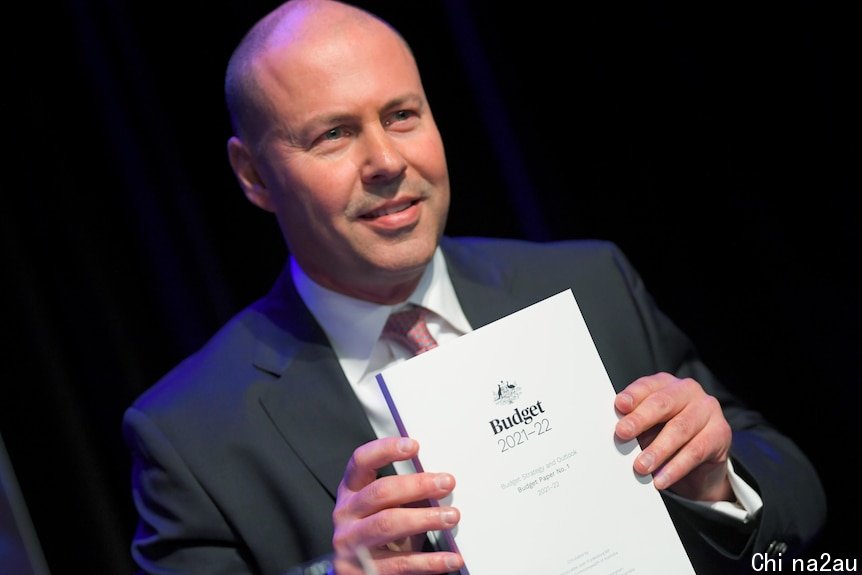 a man smiling and holding a white book