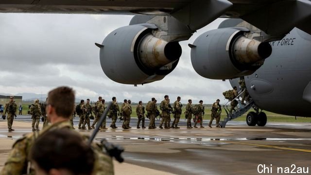 Australian soldiers queue to get on board a military aircraft headed to Solomon Islands