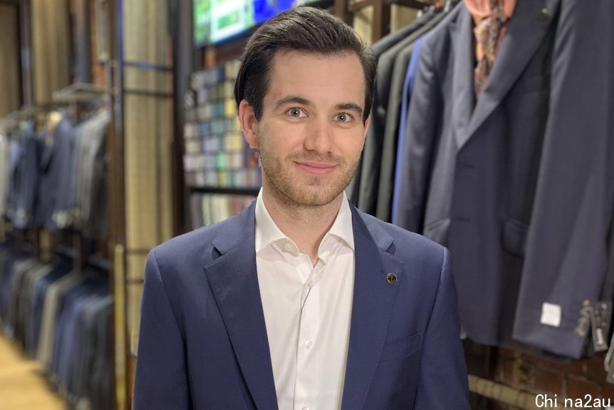 a man is in a suit store wearing a suit