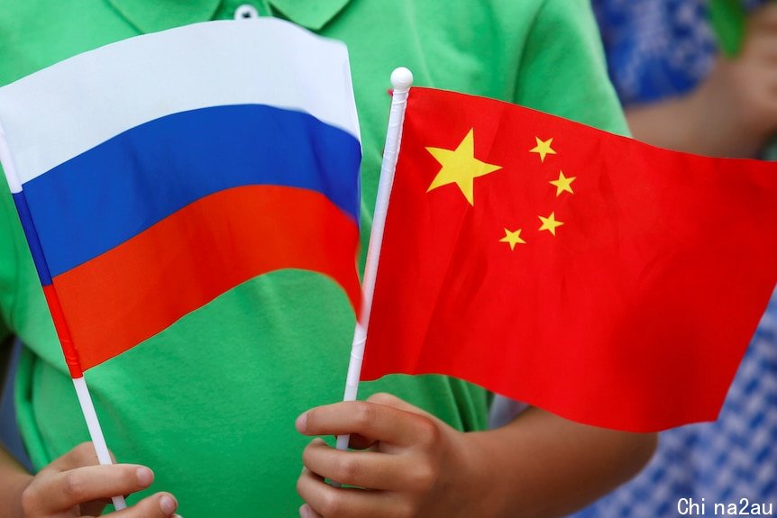 A child holds the national flags of Russia and China.