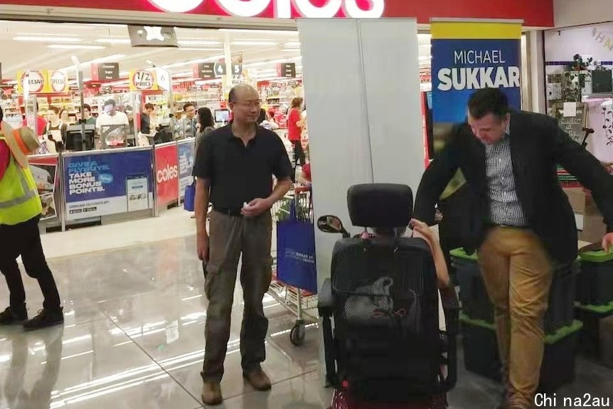 michael sukkar and a man speaking to constiuents in a shopping centre