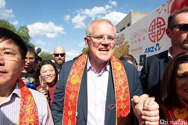 Scott Morrison walking through a crowd at a Chinese New Year celebration.