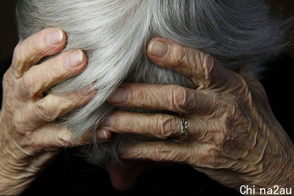 A woman holds her head in her hands