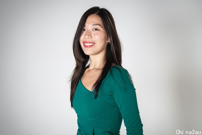 a woman smiling in front of a white background