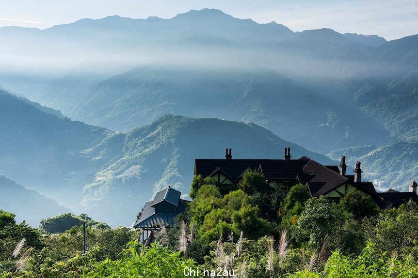 View across mountains with low clouds in the valleys and an old building in the foreground looking over the valley