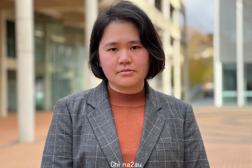 A woman stands on a university campus.