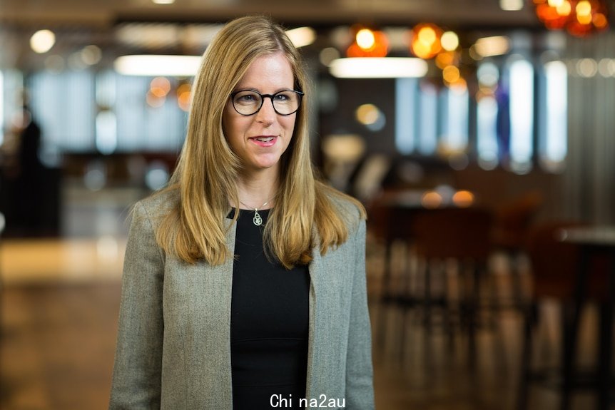 A woman stands in a lobby.