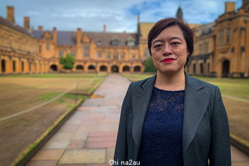 A woman stands on a uni campus.