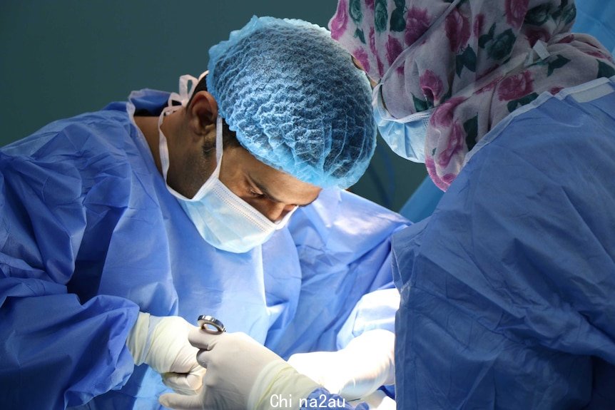 A doctor and nurse in an operating room in a hospital.