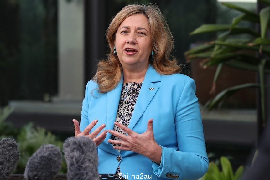 Annastacia Palaszczuk in a blue jacket outdoors at a press conference.