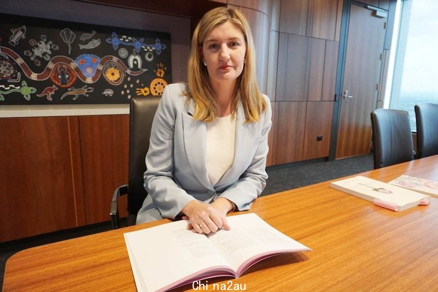 A woman sits in a board room.