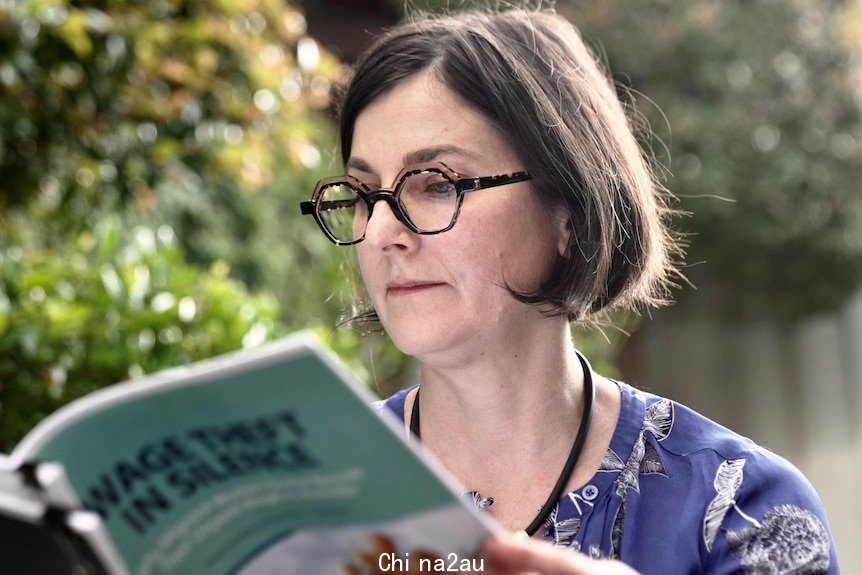 A woman reads a research paper.