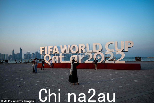 参观者在多哈与 FIFA 世界杯标志合影。HRW 呼吁足球世界机构 FIFA 敦促卡塔尔启动保护 LGBT 人群的改革