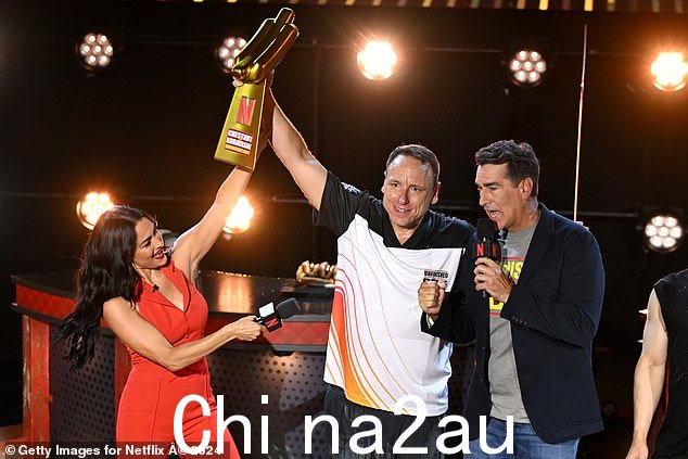 Nikki 和联合主持人 Rob Riggle（右）在获胜者 Joey Chestnut 获胜后与他合影