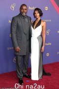 伊德里斯·艾尔巴 (Idris Elba) 身穿灰色西装，在众星云集的 2024 年黄金时段艾美奖颁奖典礼上与迷人的妻子萨布丽娜 (Sabrina) 享受约会之夜，看起来衣冠楚楚