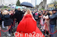 杰玛·柯林斯 (Gemma Collins) 身着巨大的红色舞会礼服，在麦当劳花车上惊喜亮相斯旺西一年一度的圣诞游行，震惊了当地人