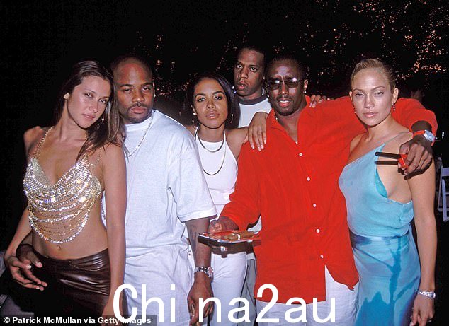 Jay-Z 在 Diddy、Jennifer Lopez、Aaliyah、Damon Dash 和 Natane Adcock 在 Diddy 2000 年 7 月 4 日派对上摆姿势拍照时在后台盘旋